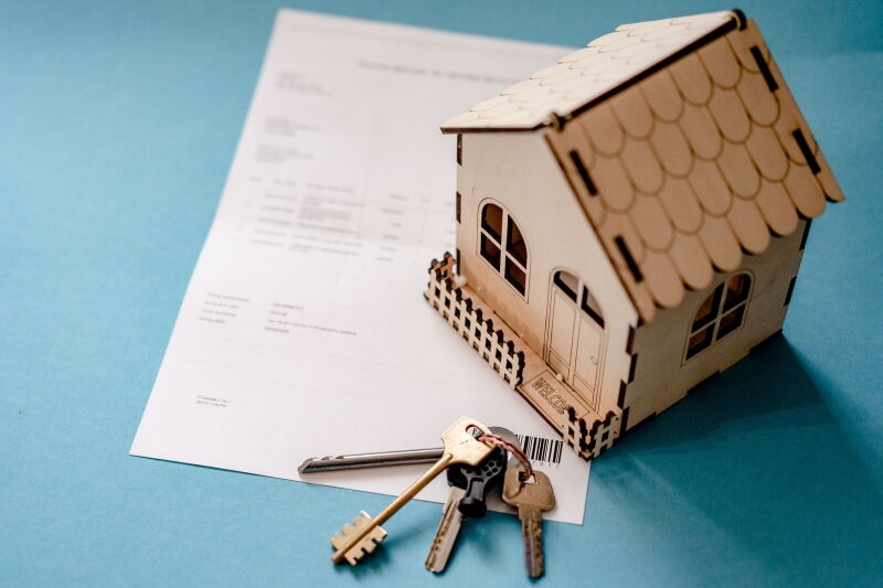 Dokument, model domu z drewna, klucze.