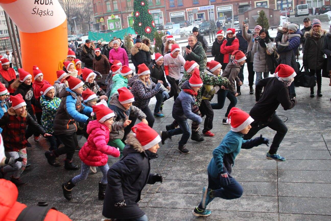 Kilkadziesiąt osób w czerwonych czapeczkach biegnie po rynku w Nowym Bytomiu.