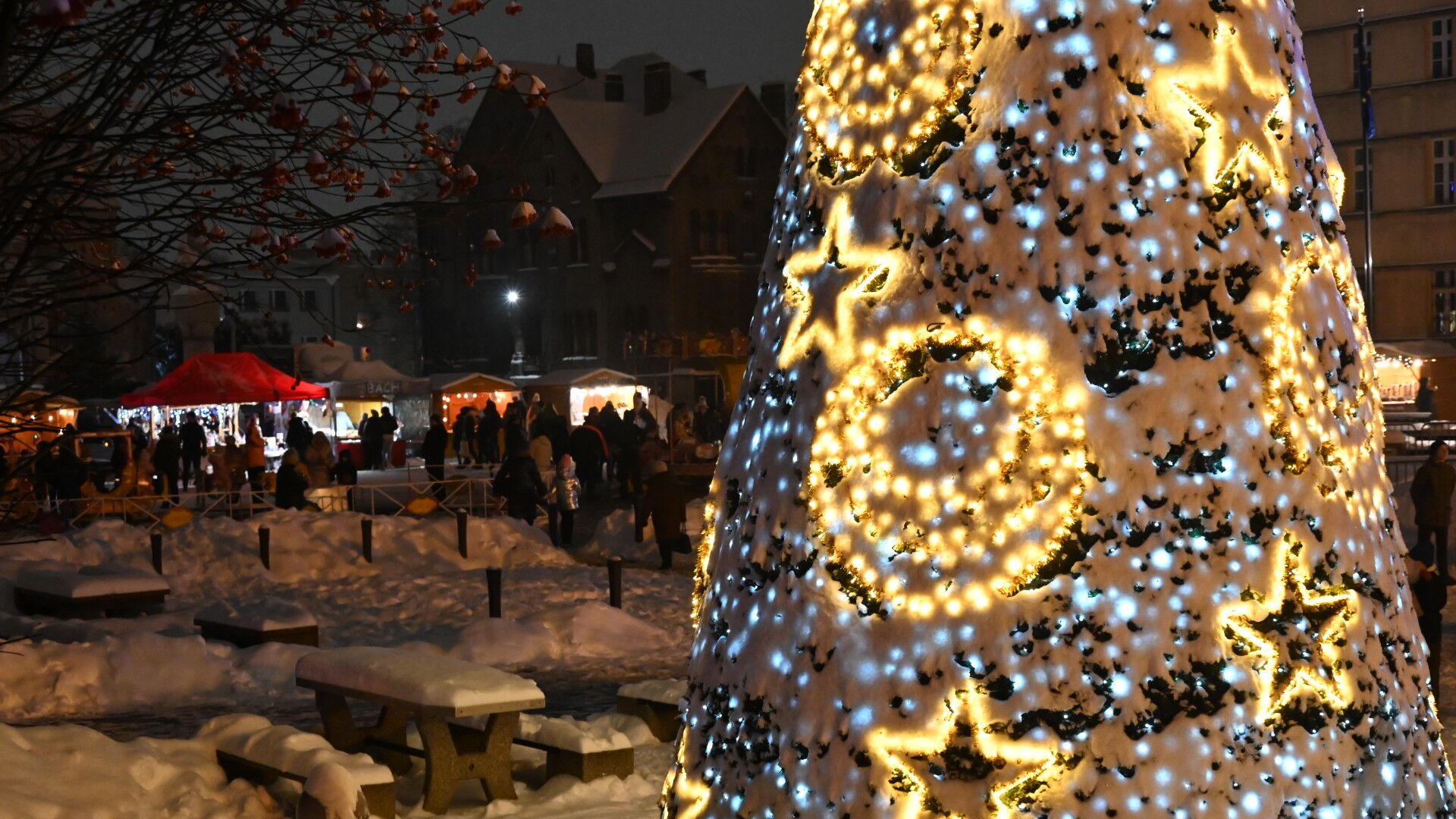 Coinka z lampkami, w tle ośnieżony plac i kramy.