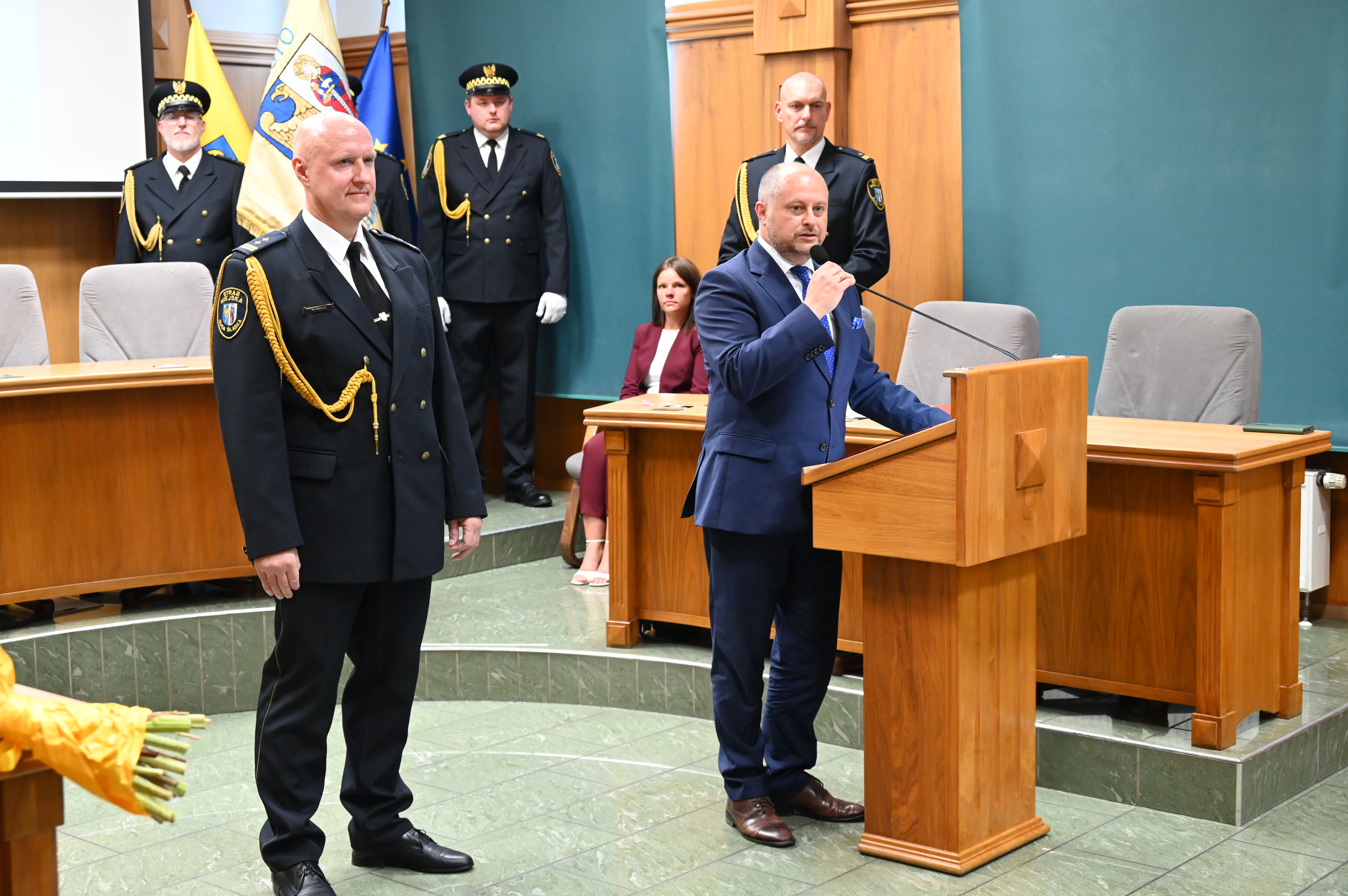 Strażnicy miejscy i prezydent miasta na środku sali.