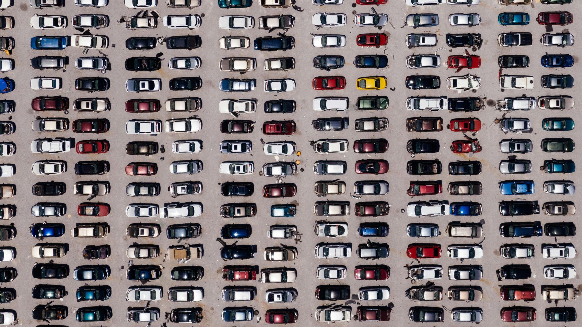 Widok z góry na rzędy samochodów na parkingu.