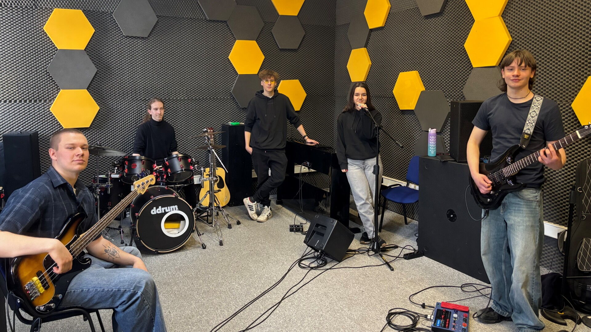 Młodzież z instrumentami muzycznymi w studiu nagrań.