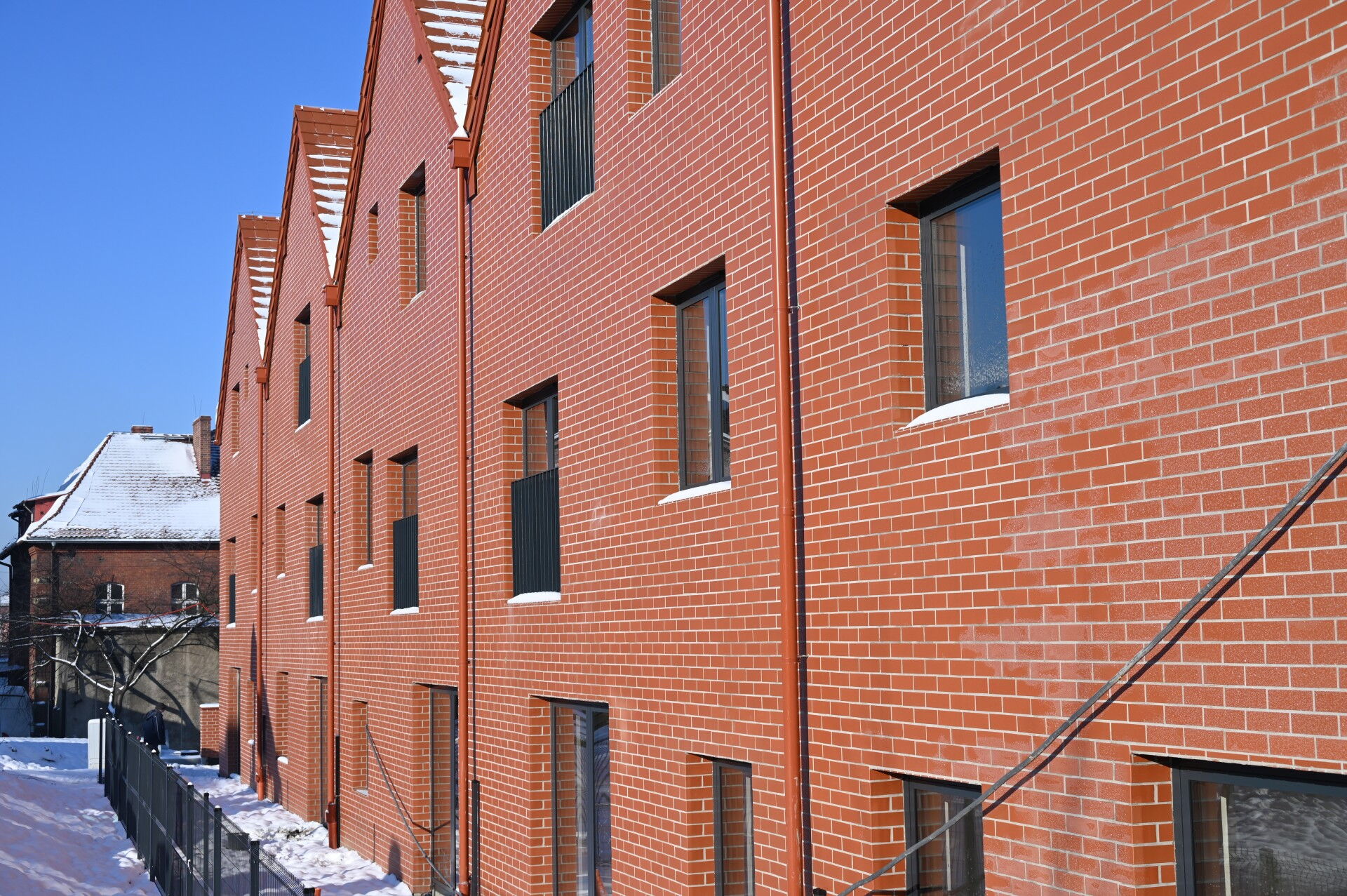 Budynek ze ścianami z cegły i skośnym dachem.