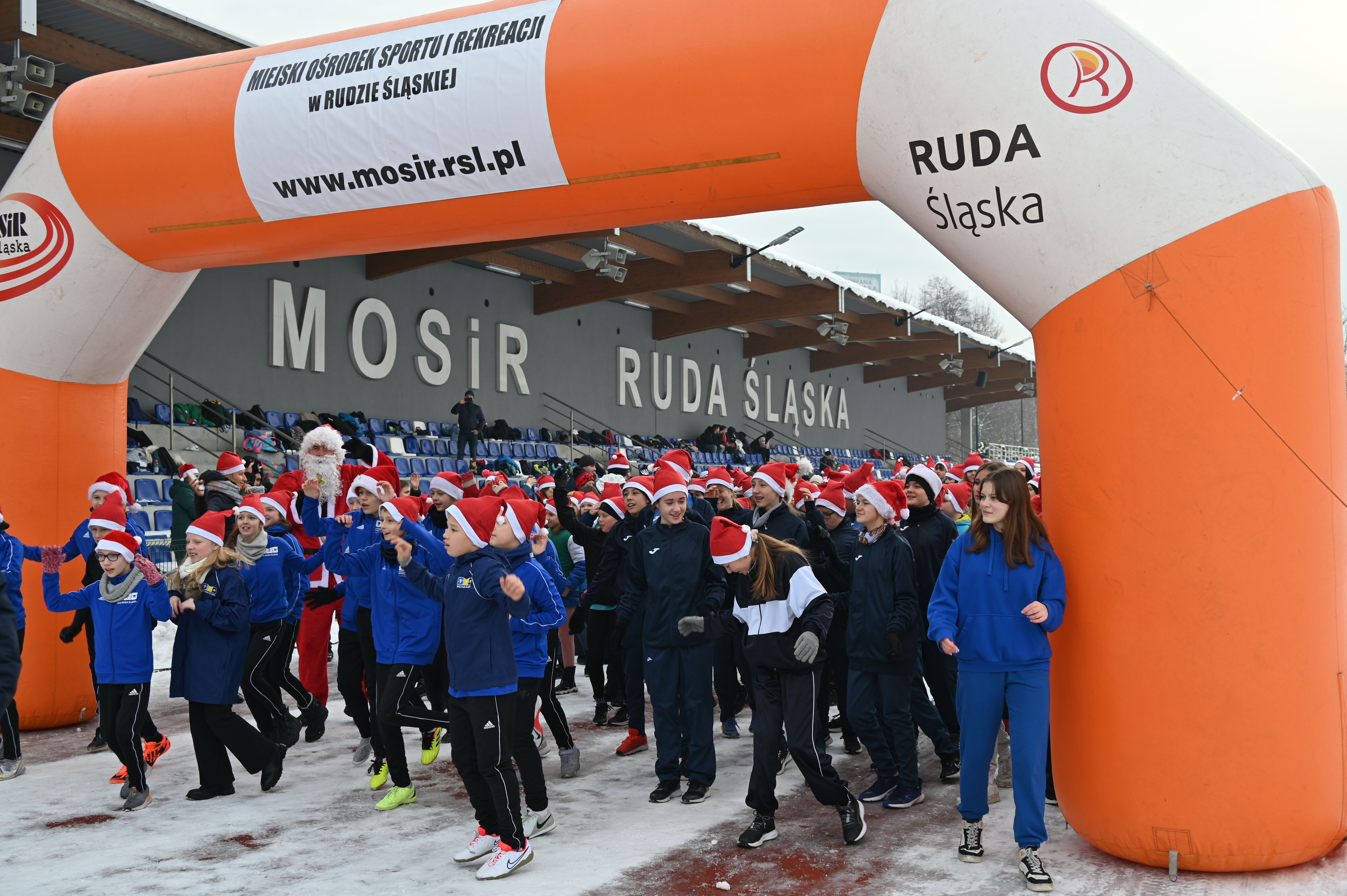 Grupa dzieci stoi przed balonem z napisem MOSiR.