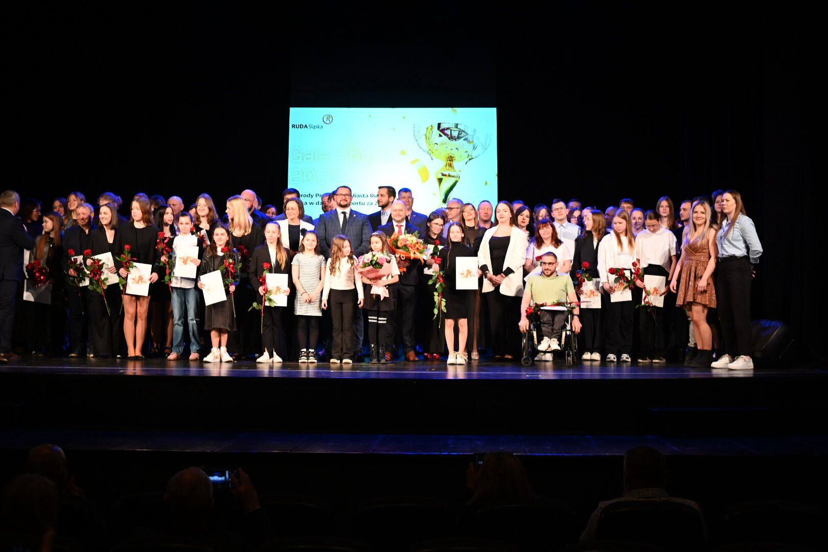 Grupa nagrodzonych sportowców pozuje do zdjęcia.