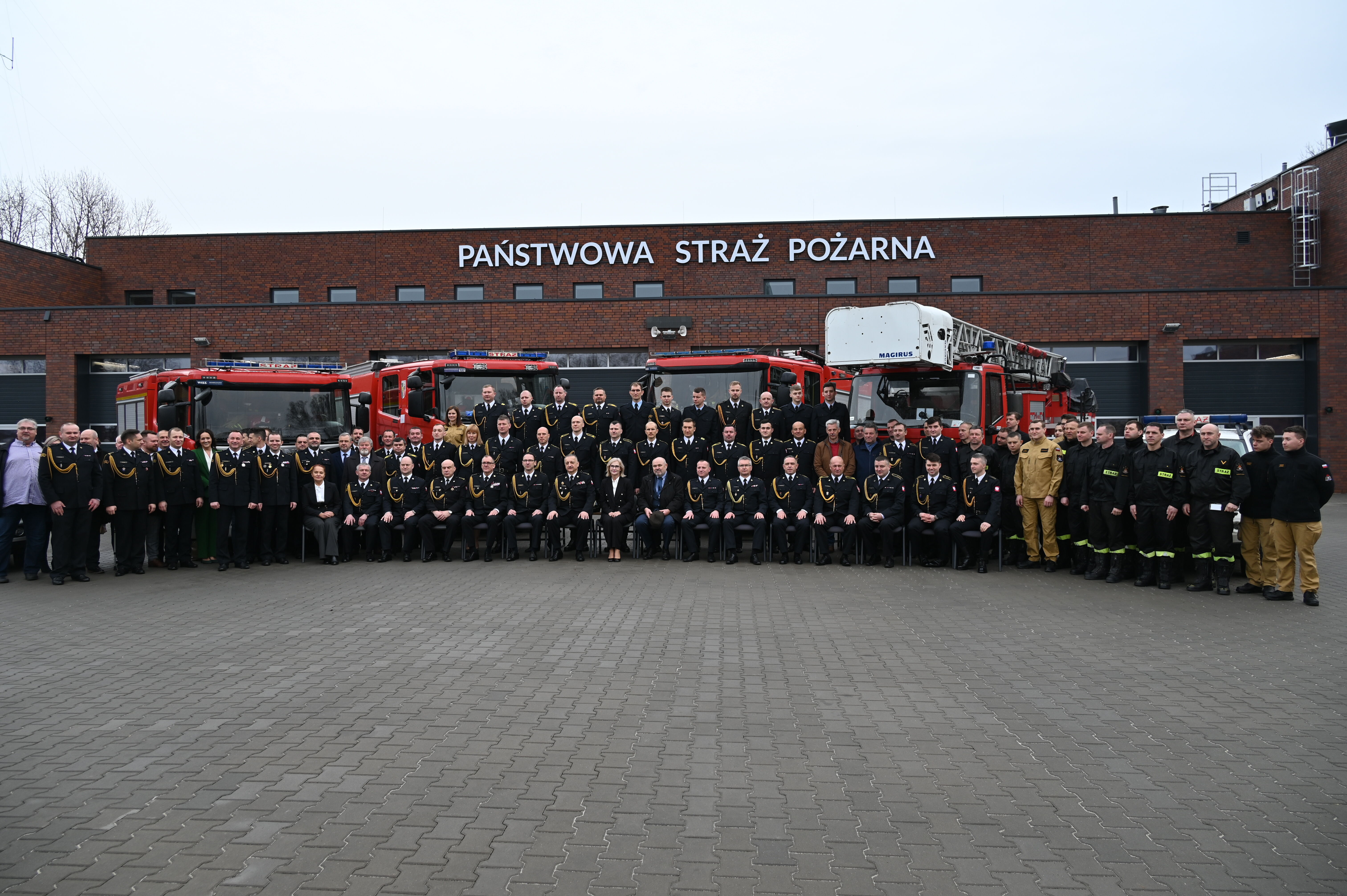 grupa strażaków przed nową remizą