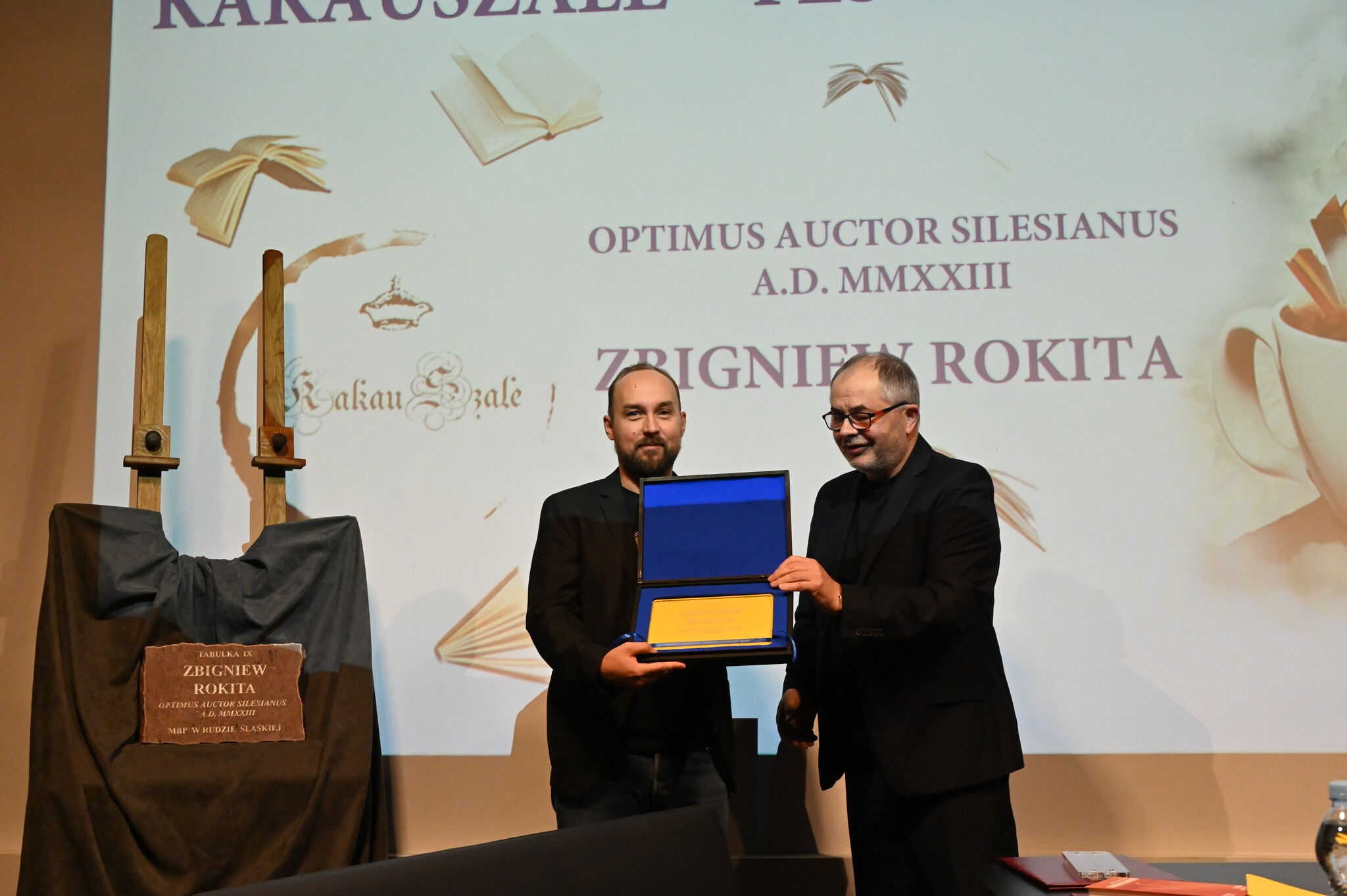 Dwóch mężczyzn trzymających tabulkę.