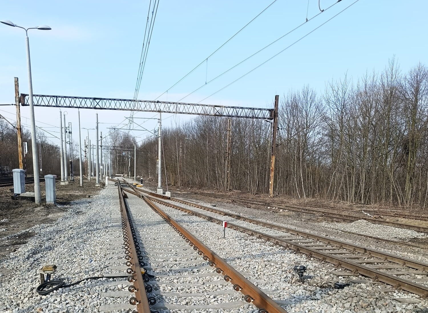Widok na szerokie tory kolejowe.