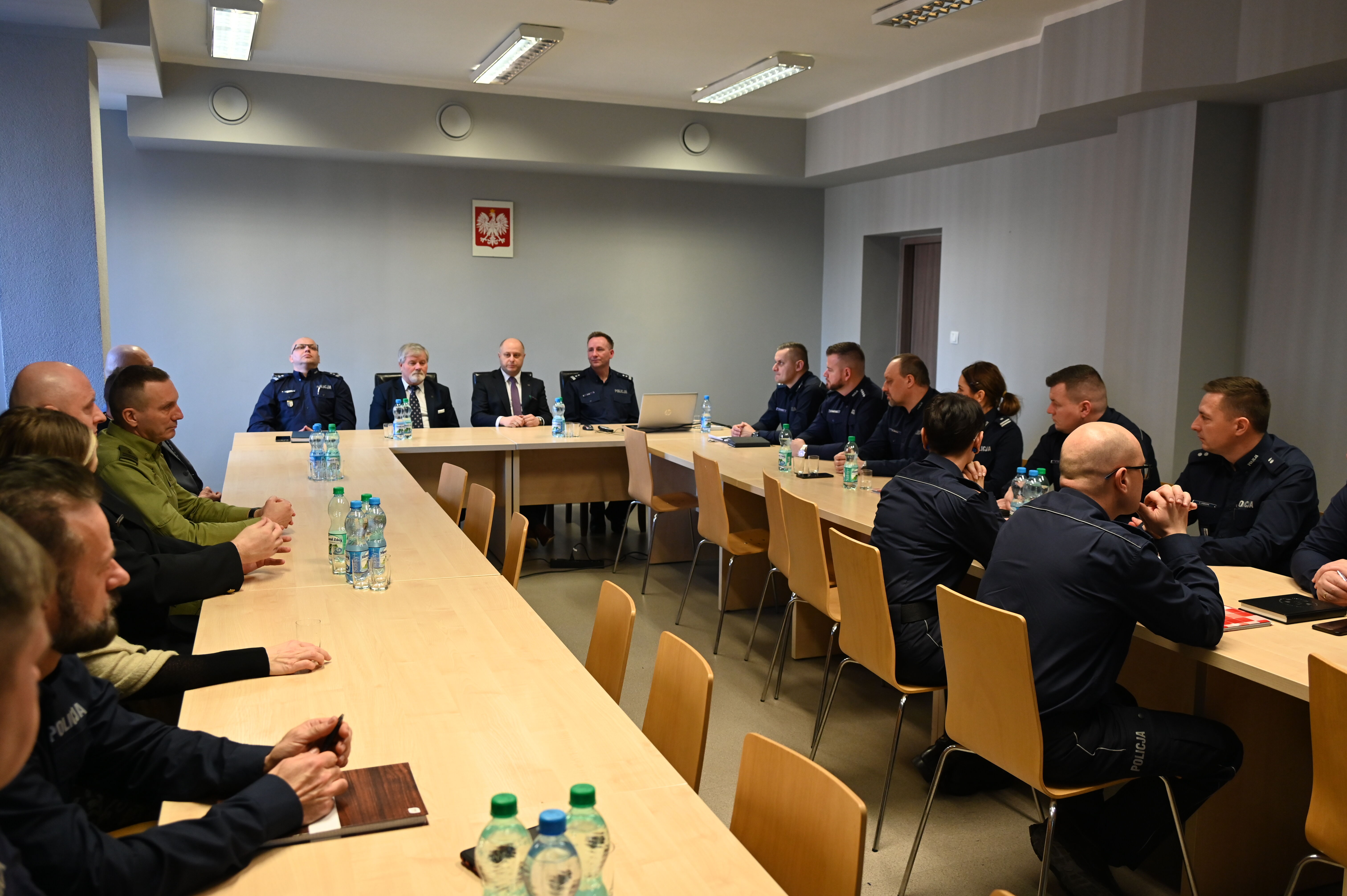 Kilkanaście osób siedzi przy stole.